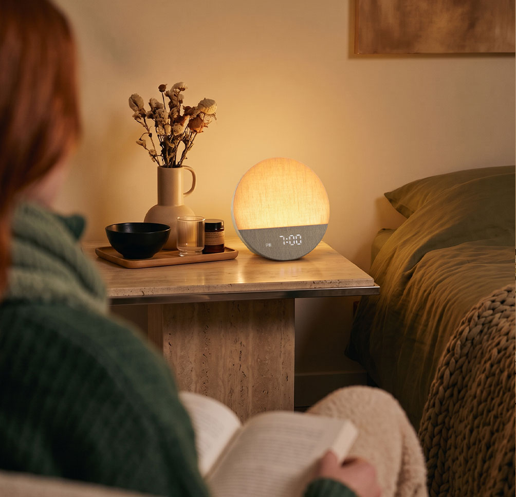 Woman reading near a Dreamegg Sunrise 1 on a bedside table